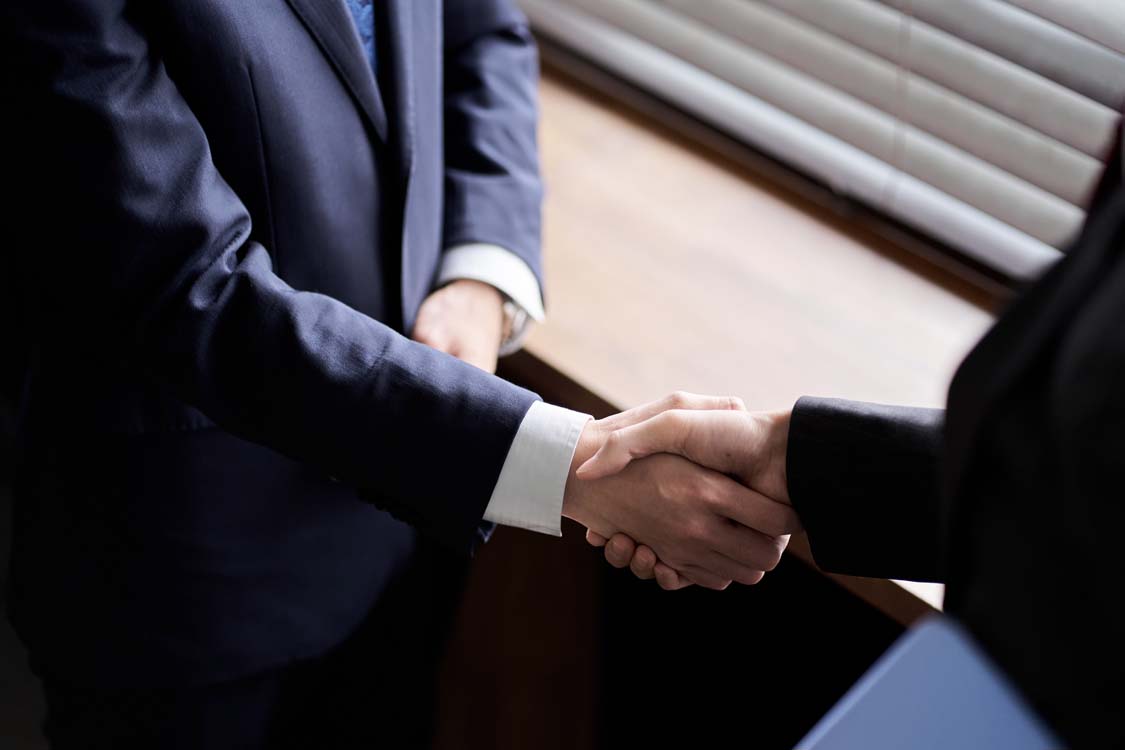 Asian business person shaking hands
